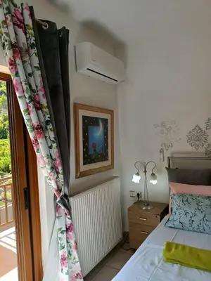 a bedroom with a bed and a window at VILLA APHRODITE SOUGIA apt1 in Kamária