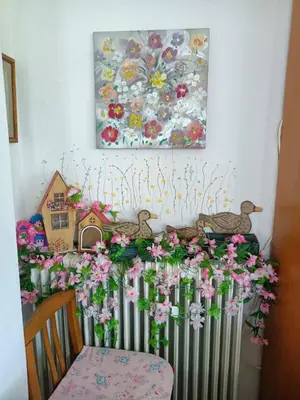 a table with flowers and a painting on the wall at VILLA APHRODITE SOUGIA apt1 in Kamária