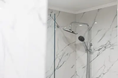 a shower in a bathroom with white marble at Callista City Living in Chania Town