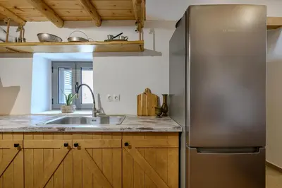 a kitchen with a stainless steel refrigerator and a sink at Nomas Home Imbros in Khóra Sfakíon