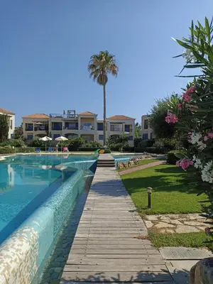 a swimming pool with a resort in the background at Infinity Night Villa in Chania Town