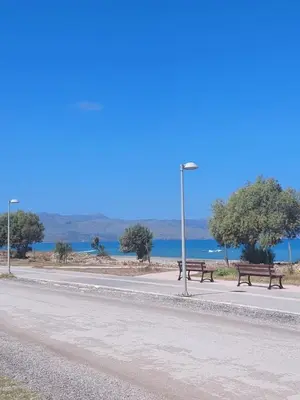 two benches on the side of a road near the water at Infinity Night Villa in Chania Town