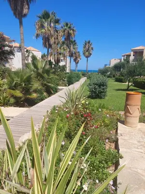 a walkway leading to a park with palm trees and flowers at Infinity Night Villa in Chania Town