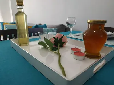 a white plate with a flower and a bottle on a table at StelisIoanna in Chania Town
