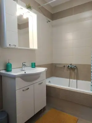 a bathroom with a sink and a tub with a mirror at StelisIoanna in Chania Town