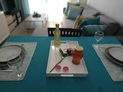a table with a plate with a bottle and glasses on it at StelisIoanna in Chania Town