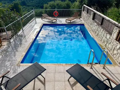 a swimming pool with two chairs and a table at Villa Albama in Darmarochori