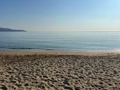 a sandy beach with the ocean in the background at Kerdos Home in Kalyves
