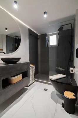 a bathroom with a black tub and a sink at Casa Moca in Chania Town