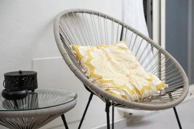 a white chair with a yellow pillow and a table at Casa Moca in Chania Town