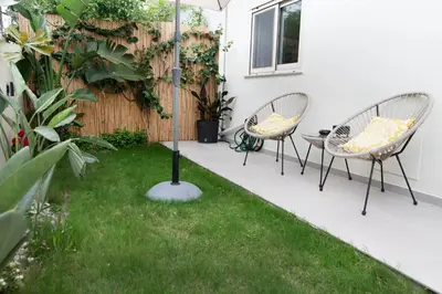 a patio with two chairs and a table in the grass at Casa Moca in Chania Town