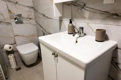 a bathroom with a white sink and a toilet at Adriana Apartment in Agia Marina Nea Kydonias