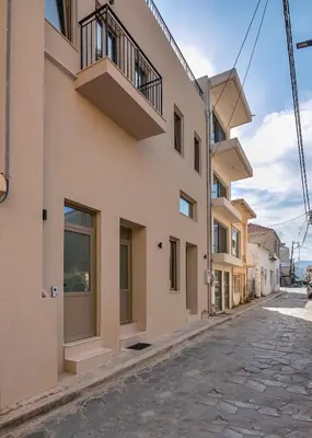 a building with balconies on the side of a street at Eva's apartments in Kissamos