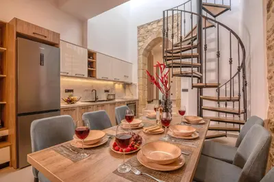 a dining room with a table with wine glasses at Eva's apartments in Kissamos
