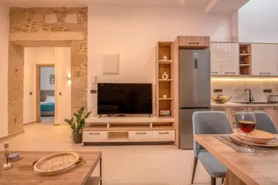 a kitchen and living room with a large television at Eva's apartments in Kissamos