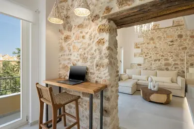 a living room with a table with a laptop on it at il Campanile Luxury Living in Chania Town