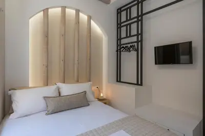 a bedroom with a white bed with a tv on the wall at il Campanile Luxury Living in Chania Town