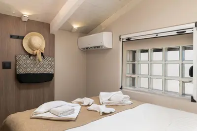a bedroom with towels on a bed with a window at Lovelia Maisonette Chania in Chania Town