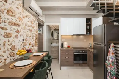 a kitchen with a wooden table and chairs at Lovelia Maisonette Chania in Chania Town