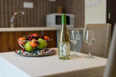 a bottle of wine and a bowl of fruit on a counter at Helios studio next to the sea BY APOKORONAS-VILLAS in Kalyves