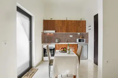 a kitchen with a table with a bowl of fruit on it at Helios studio next to the sea BY APOKORONAS-VILLAS in Kalyves