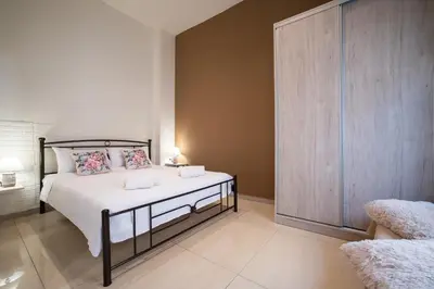 a bedroom with a bed and a wooden cabinet at Helios studio next to the sea BY APOKORONAS-VILLAS in Kalyves
