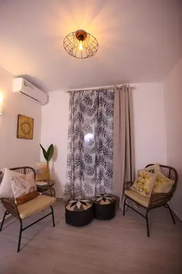 a living room with two chairs and a window at Kabanas suite 1 in Chania Town