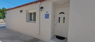 a white building with a door and a window at Aeropis Villa, Chania in Chania Town