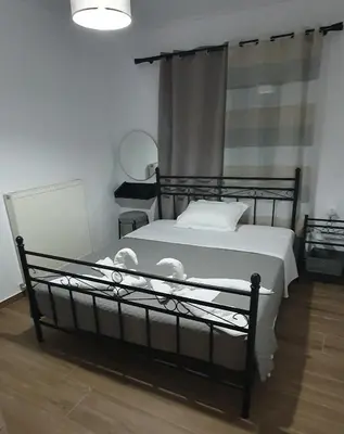 a bedroom with a black bed with white sheets at Aeropis Villa, Chania in Chania Town
