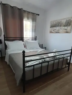 a bedroom with a black bed with white pillows at Aeropis Villa, Chania in Chania Town