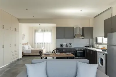 a kitchen and living room with a couch and a table at Oliva Verde Residences in Galatás