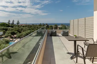a balcony with a table and chairs on a building at Oliva Verde Residences in Galatás