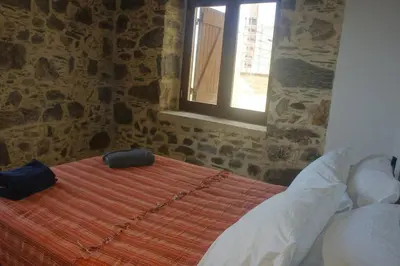a bedroom with a bed with two bags on it at Rosales stone house in AmigdhalokeFálion
