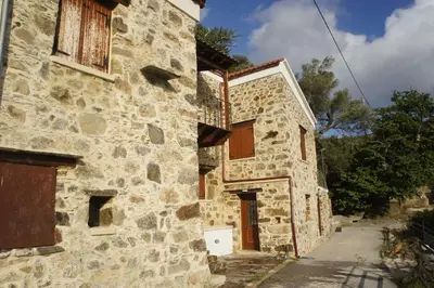 an old stone building with a door on a street at Rosales stone house in AmigdhalokeFálion