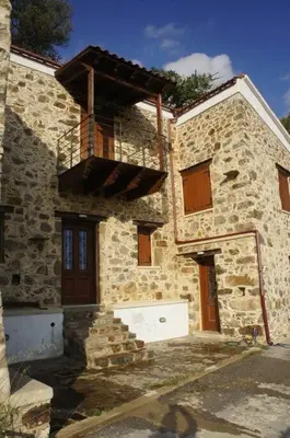 a stone building with a balcony on the side of it at Alegria stone house in AmigdhalokeFálion