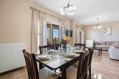 a dining table and chairs in a living room at Patelakis Apartment near the Beach in Chania Town