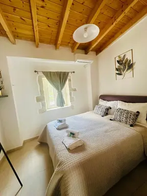 a bedroom with a large bed with a window at Julia's cottage in Kalyves