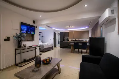 a living room with a couch a table and a kitchen at Black Suites in Chania Town