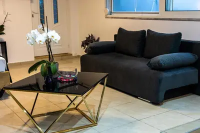 a living room with a couch and a glass table at Black Suites in Chania Town