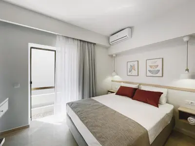 a bedroom with a large bed and a window at Urban Hive Chania, Your City Basecamp - Fiber Wifi in Chania Town