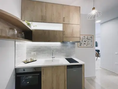 a kitchen with wooden cabinets and a sink at Urban Hive Chania, Your City Basecamp - Fiber Wifi in Chania Town