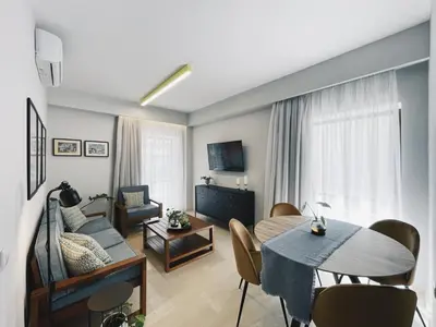 a living room with a dining room table and a couch at Urban Hive Chania, Your City Basecamp - Fiber Wifi in Chania Town