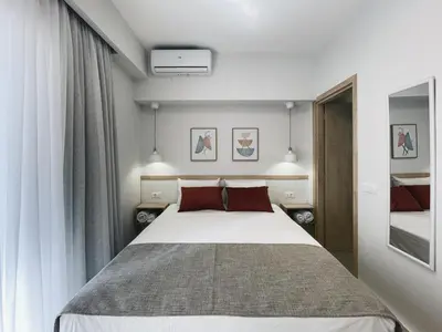 a bedroom with a large white bed with red pillows at Urban Hive Chania, Your City Basecamp - Fiber Wifi in Chania Town