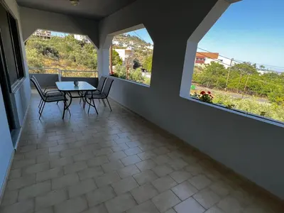 a balcony with a table and chairs and two windows at blue and green II in Chania Town
