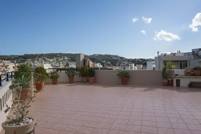 a large patio with potted plants on a roof at SunShine studio in Chania Town