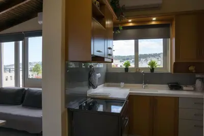 a kitchen with a sink and a living room at SunShine studio in Chania Town