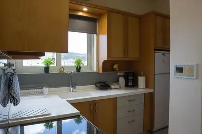 a kitchen with wooden cabinets and a sink and a window at SunShine studio in Chania Town