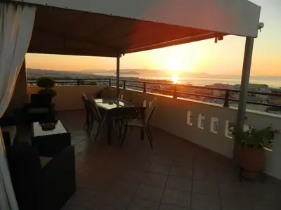 a balcony with a table and chairs and the sunset at SunShine studio in Chania Town