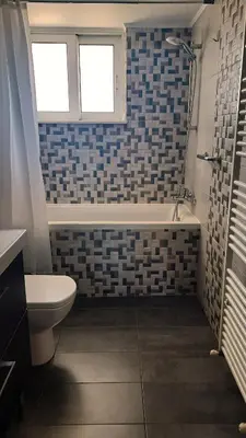 a bathroom with a tub and a toilet and a window at Elena Apartments in Kato Daratso