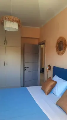 a bedroom with a large bed with a blue bedspread at Elena Apartments in Kato Daratso